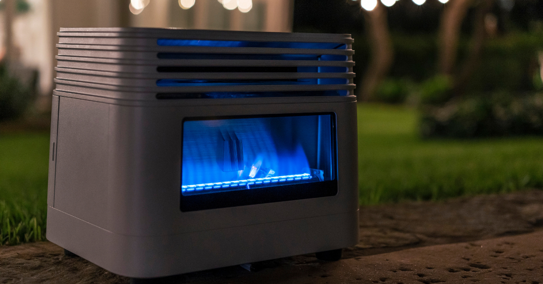 Outdoor modern gray gas heater with blue flame on patio stone floor at night