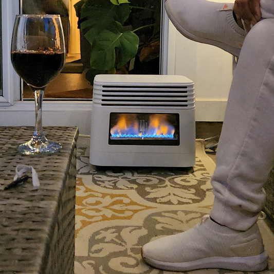Outdoor patio scene with portable gas heater, glass of red wine on wicker table, and person in light sneakers