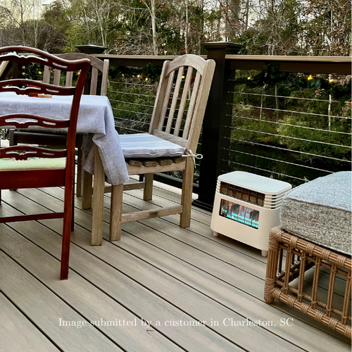 Outdoor deck with chairs, table, and a portable heater on a wooden floor.