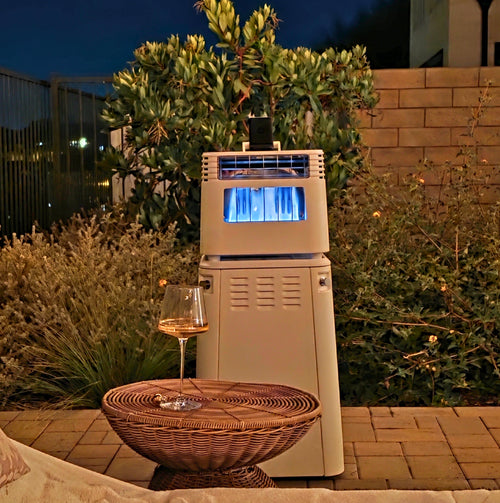 Outdoor patio gas heater with blue flame near wicker table holding a glass of wine at night