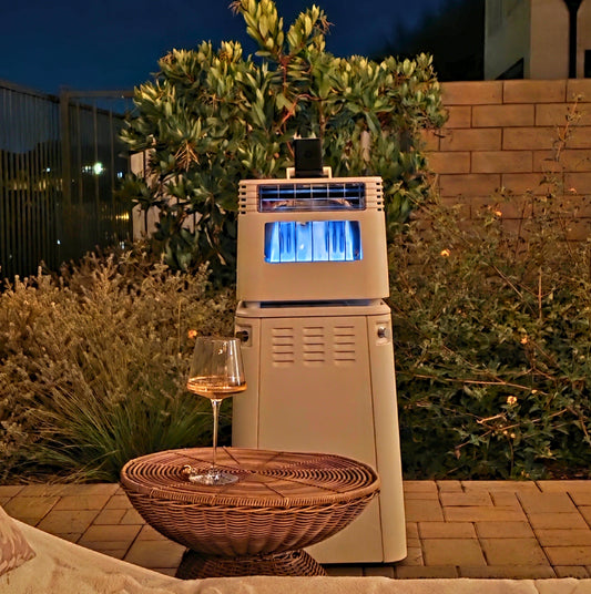 Outdoor patio gas heater with blue flame near wicker table holding a glass of wine at night